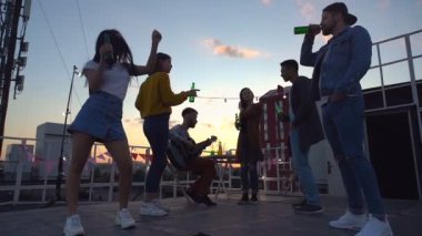 Çatı partisinde dans eden altı arkadaştan oluşan bir grup. Gün batımı zamanı.