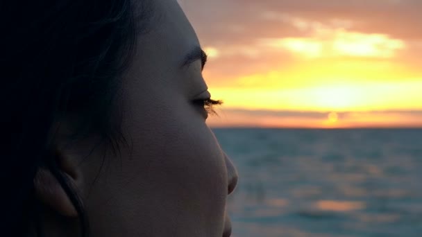 海の夕日を眺めているアジア人女性の肖像画をクローズアップ — ストック動画