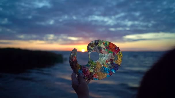 Vrouwelijke Hand Holding Verf Palet Boven Zonsondergang Landschap Zee — Stockvideo