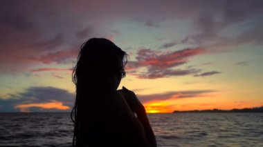 Denizde genç bir kadının portresi. Gün batımı zamanı. Slowmotion.