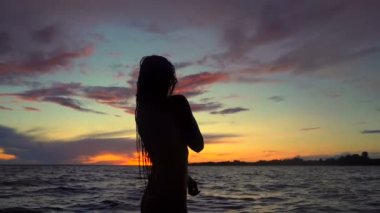 Denizde genç kadın kadın siluet. Kapalı üstsüz. Slowmotion. El çekimi.