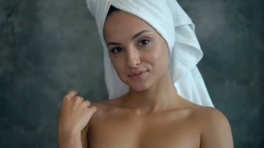 Genç beyaz kadının portresini kapat. Banyo odasında ayakta, gülümseyen ve kamera bakıyor. Hoşça kal jest ve hava öpücüğü.