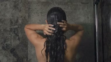 Banyoda duş alan kadın. Arkadan görüntüle.