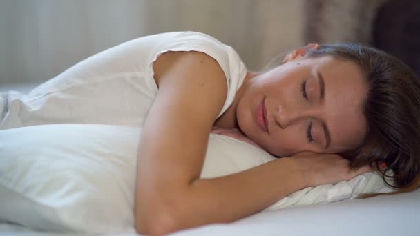 ベッドに横たわり 枕を抱きしめ 寝ている魅力的な女性 ハンドヘルドショット — ストック動画