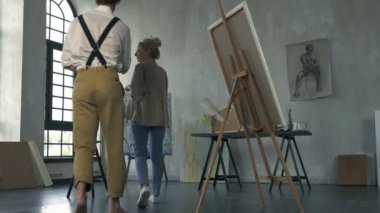 Sanatçı kadın stüdyo işyerinde erkek modeli davet ve onu çizmeye başlıyor.