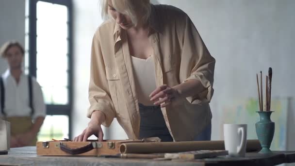 Vrouwelijke Schilder Het Kiezen Van Schildergereedschappen Aan Tafel Terwijl Mannequine — Stockvideo