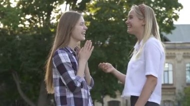 Parkta açık havada konuşan iki kız arkadaş.