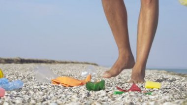 Gönüllü plajda yürüyüş ve plastik ve diğer çöp toplama. Çöp çubuğu kullanarak. Slowmotion.