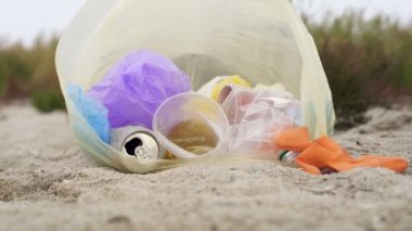 Çöp ler deniz plajındaki plastik torbada yatıyor. Slowmotion.
