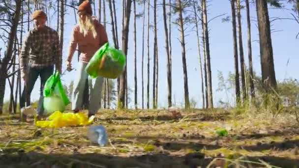 一群朋友 志愿者 从森林的地面捡起塑料和其他垃圾 手持式拍摄 低角度 — 图库视频影像