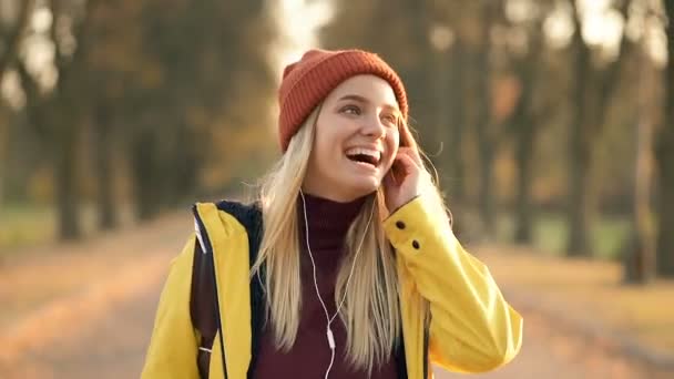 Happy Smiling Woman Walking Autumn Park Listening Music Handheld Shot — ストック動画