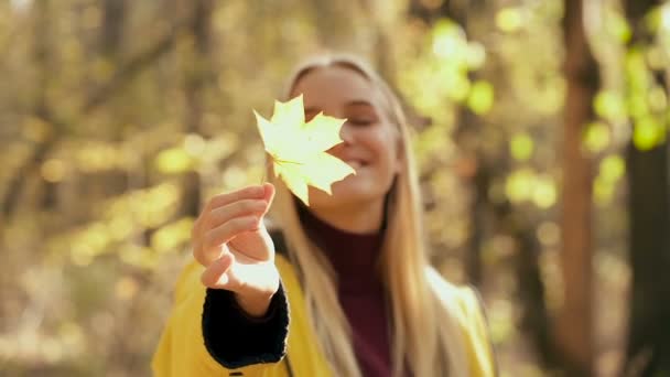 Retrato Una Mujer Sonriente Sosteniendo Una Hoja Arce Amarillo Ella — Vídeo de stock