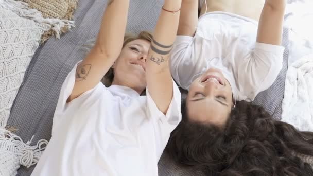 听音乐 在床上玩乐的女伴 慢动作 — 图库视频影像