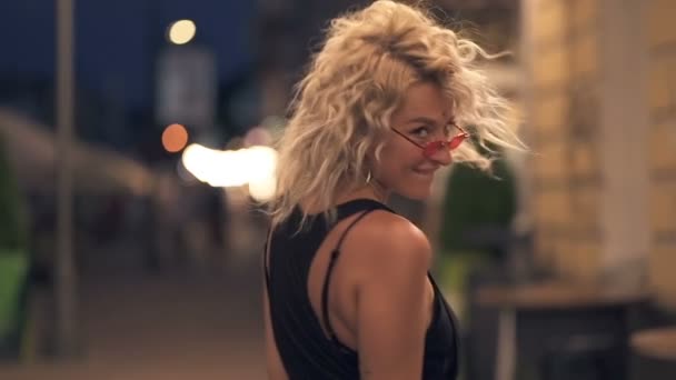 Mujer Pelo Rizado Feliz Caminando Calle Noche Vuelta Sonriendo Mirando — Vídeos de Stock