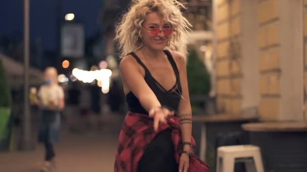 Blondynka Kręcone Włosy Kobieta Chodząca Ulicy Wieczorem Odwraca Się Patrząc — Wideo stockowe