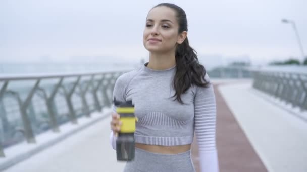 Jovem Mulher Apto Andando Bebendo Água Após Treinamento — Vídeo de Stock