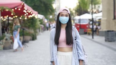 Sokakta durup kameraya bakan Asyalı genç bir kadının portresi. Yavaş çekim.