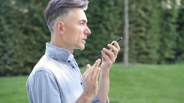 Adult Man Walking Park Holding Mobile Phone Talking Slowmotion — Stock Video
