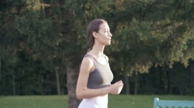 Parkta koşan sportif bir kadın. Yavaş çekim.