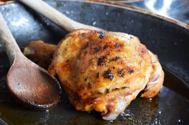 şişman bir tavada kızarmış tavuk parçası