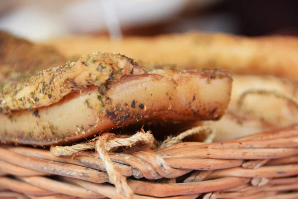 smoked bacon in paprika and lard in cubes on a stall in a wicker basket