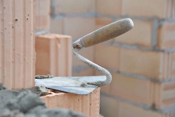 bricklaying trowel on a brick wall