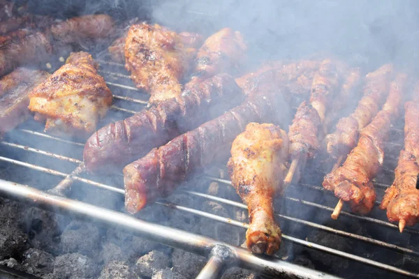 Poulet rôti, saucisses et brochettes sur le gril dans la fumée — Photo