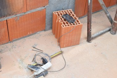 şantiyede kirli cep telefonu bir tuğla yatıyor