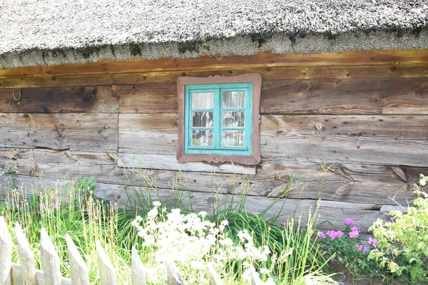 Blauwe vernietigd venster in een rustiek houten huisje in de open lucht — Stockfoto