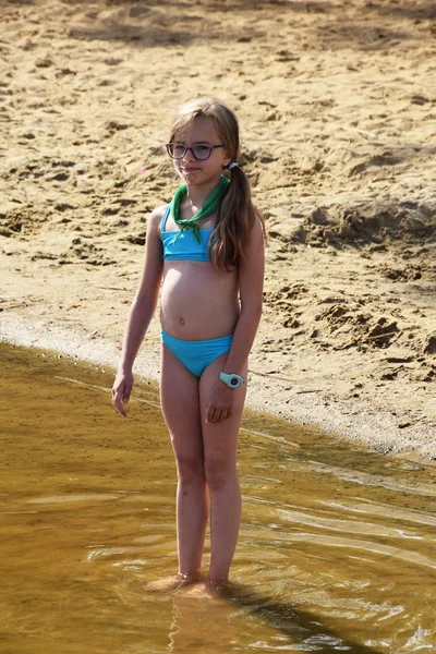 Niña en traje de baño en la orilla del lago — Foto de Stock