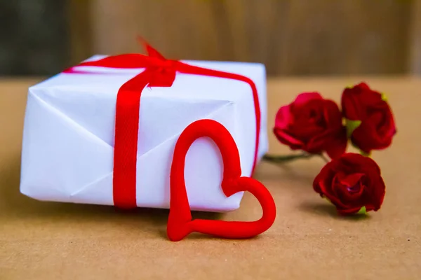 Gift box and flowers on the table. Valentine\'s Day or wedding greeting card