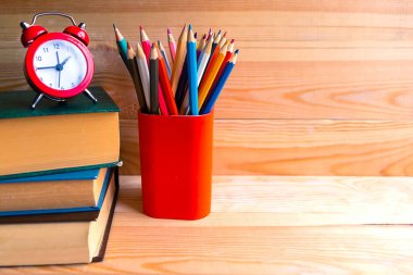 Kalem standı ve tahta arka planda bir yığın kitap. Metin için alanı kopyala. Eğitim kavramı