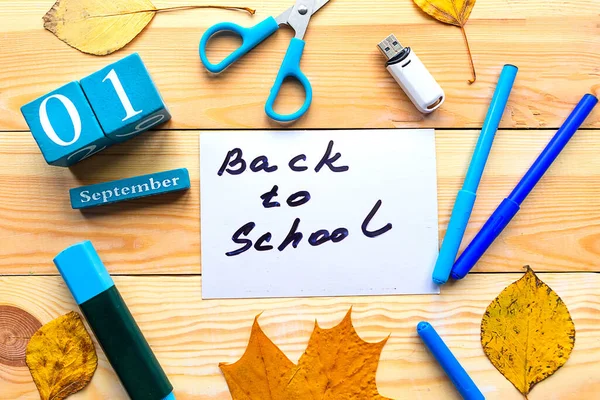 School supplies and card with message Back to School on wooden tabletable. School quarantine concept