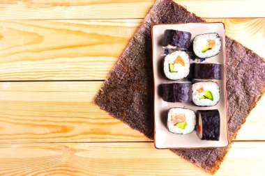 Tabakta suşi ruloları, üst manzara, ahşap arka plan.