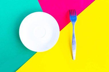 Yeşil geometrik arka planda beyaz model plaka ve çatal. Metin için alanı kopyala. Asgari konsept