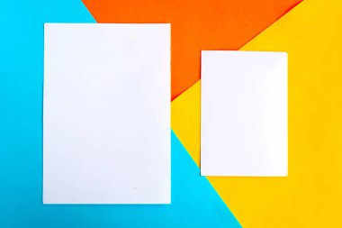 Geometrik mavi, turuncu ve sarı arka planda iki beyaz model boş. Minimum konsept. Metin için alanı kopyala