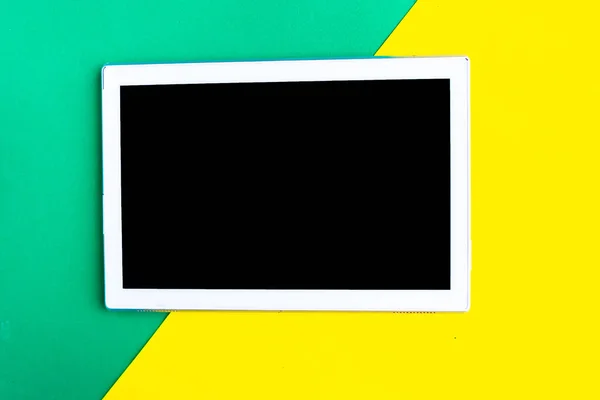 幾何学的な緑と黄色の背景に黒いモックアップ画面を持つタブレット テキストのスペースをコピーします ミニマルなコンセプト — ストック写真