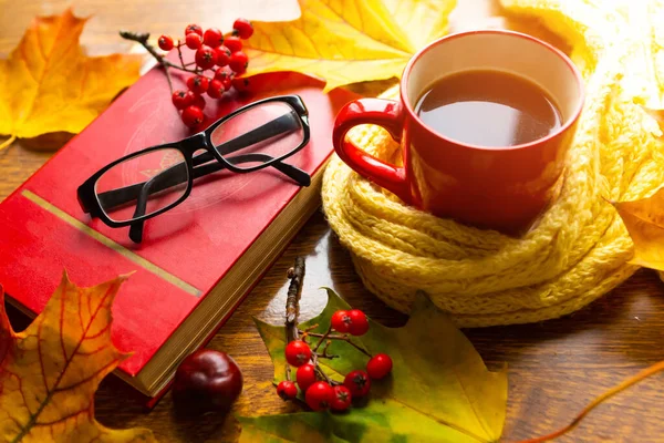 Kahve fincanı, eski kitap ve bardaklar masanın üstünde. Ekim arkaplanı