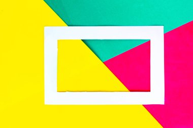 Parlak geometrik yeşil ve sarı arkaplanda beyaz fotoğraf çerçevesi. Minimum konsept. Metin için alanı kopyala