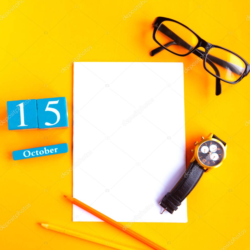 October the 15th. Flat lay photo with calendar, white mockup blank, glasses and watch on bright orange background