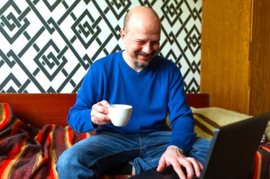 Adam evde bilgisayarla çalışıyor. Serbest meslek kavramı. Çevrimiçi iş kavramı