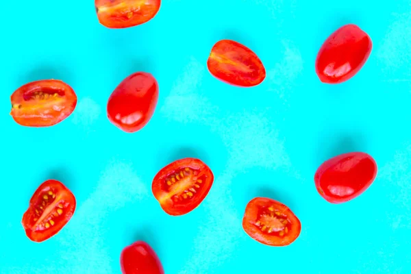 Fresh cherry tomatoes pattern on bright blue background, minimal concept