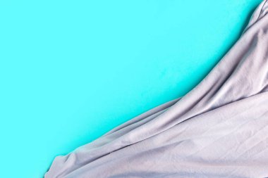 Pastel mavi arkaplan üzerinde gri ipek malzeme, metin için kopyalama alanı