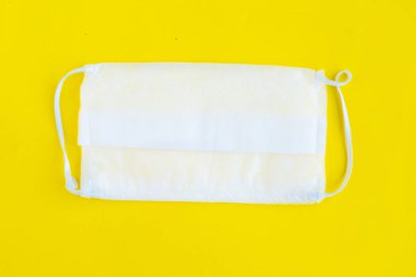 Parlak sarı arka planda tıbbi maske, minimum konsept