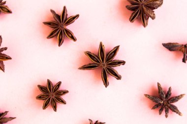 Pastel pembe arka planda yıldız anason deseni, minimum konsept