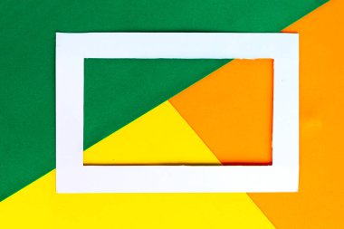 Renkli geometrik arkaplanda beyaz fotoğraf çerçevesi. Metin için alanı kopyala. Asgari konsept