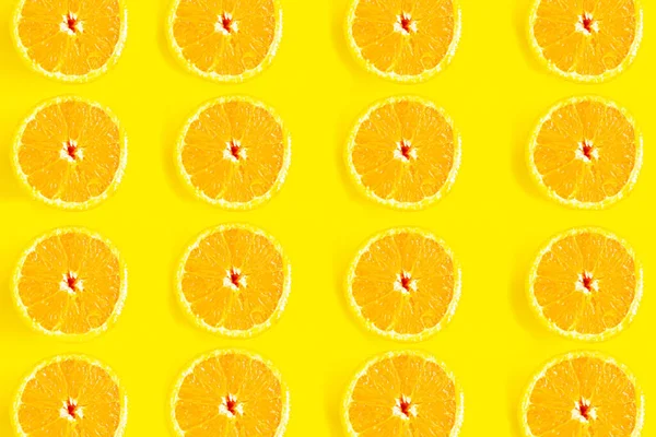 Sliced oranges pattern on yellow background, minimal concept
