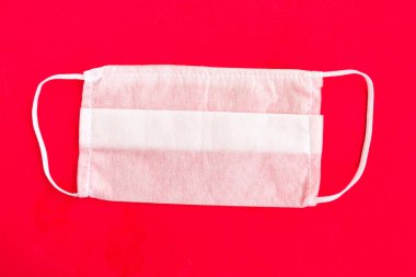 Parlak kırmızı arka planda tıbbi maske, covid-19 konsepti