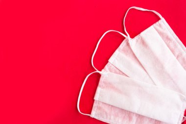Parlak kırmızı arka planda tıbbi maskeler, covid-19 konsepti