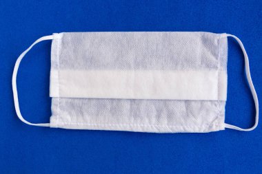Koyu mavi arka planda tıbbi maske, covid-19 konsepti